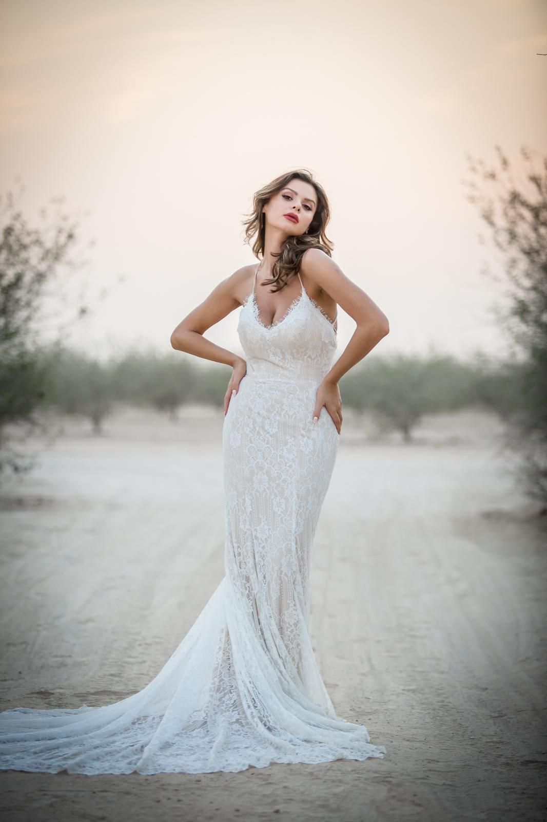 Editorial bridal portrait in a fitted lace gown among olive trees
