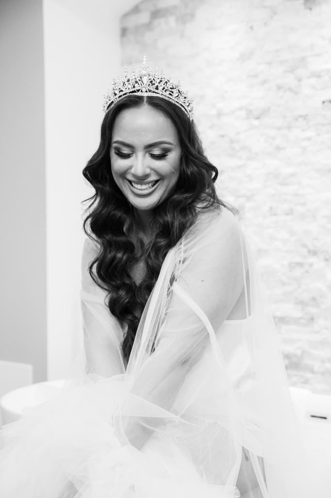 Black and white portrait of a smiling bride wearing a tiara
