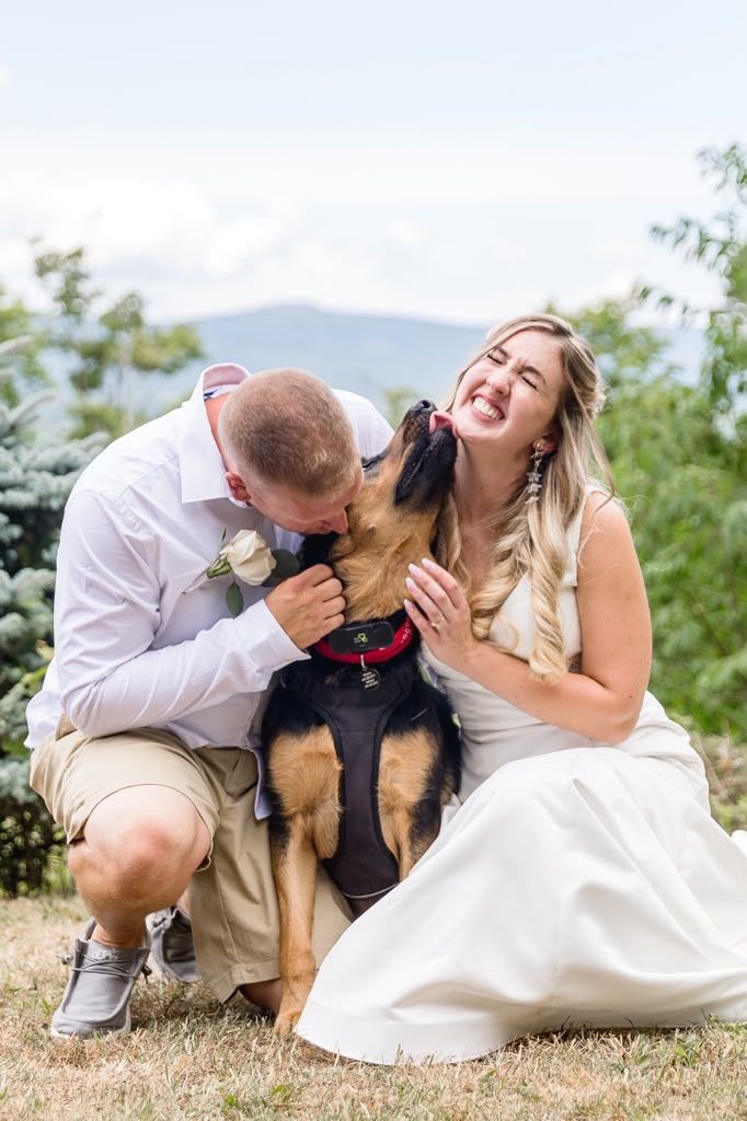 Couple sharing a laugh with their dog on their wedding day