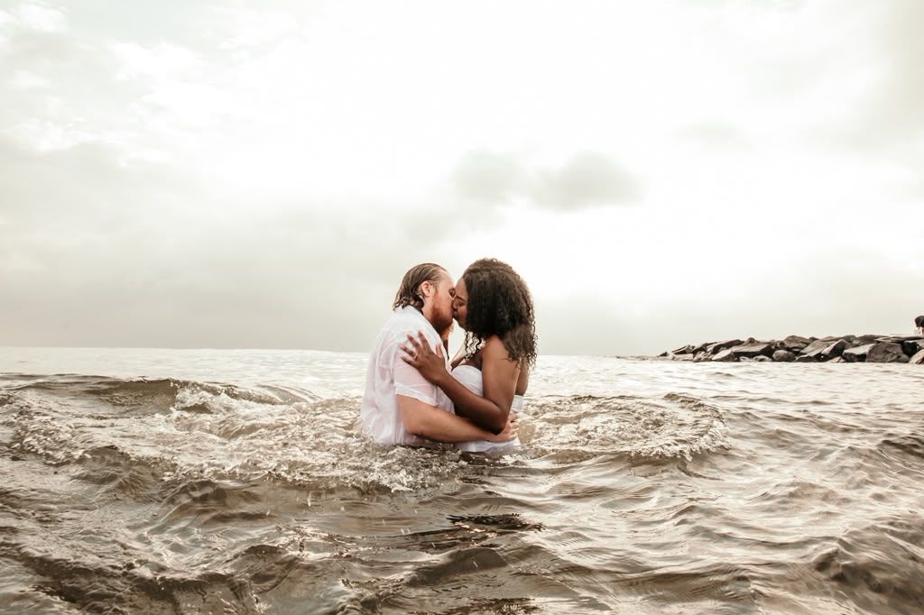 Couple embracing waist-deep in ocean waves