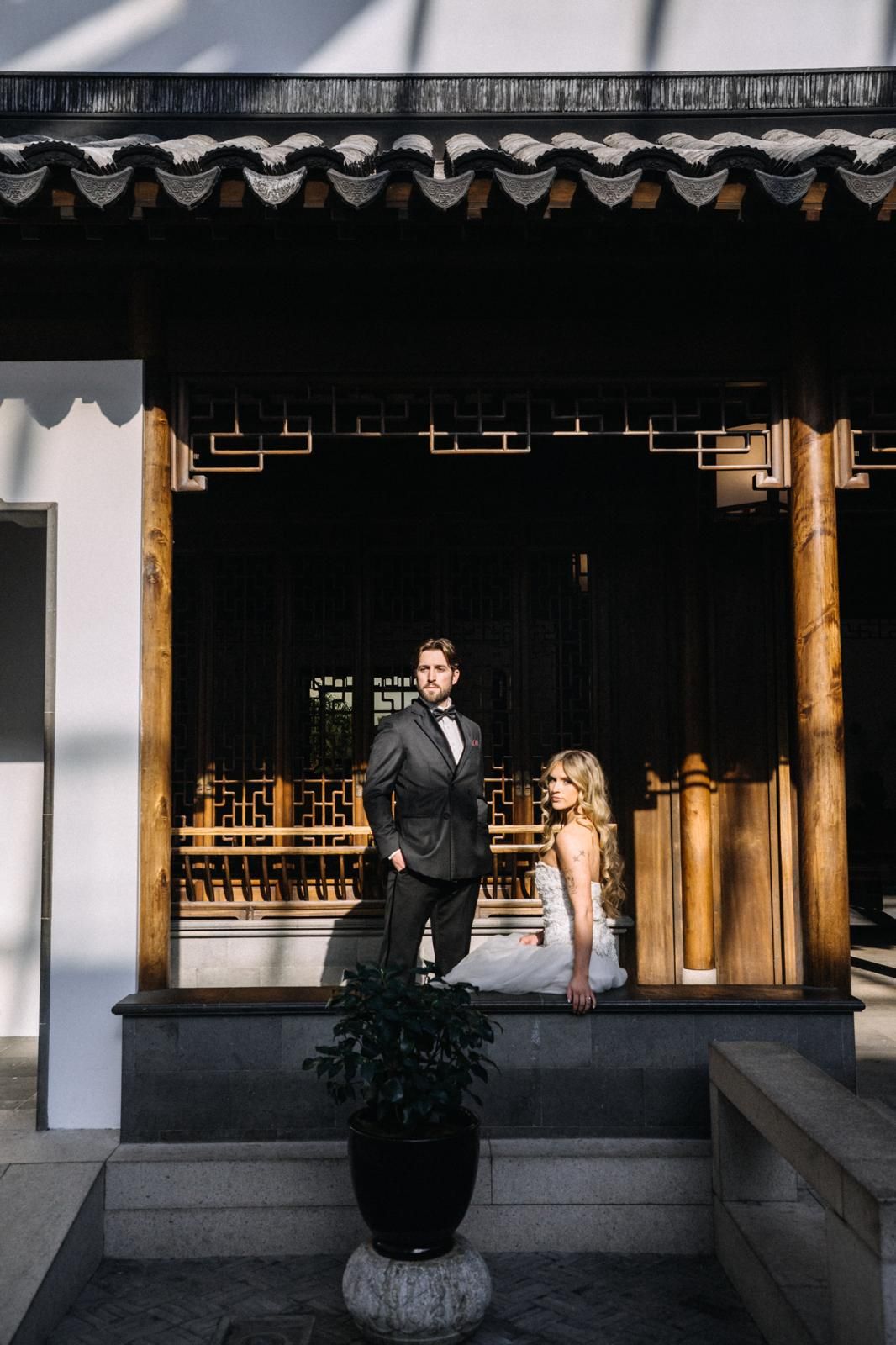 Couple posed on the steps of a traditional pagoda garden pavilion