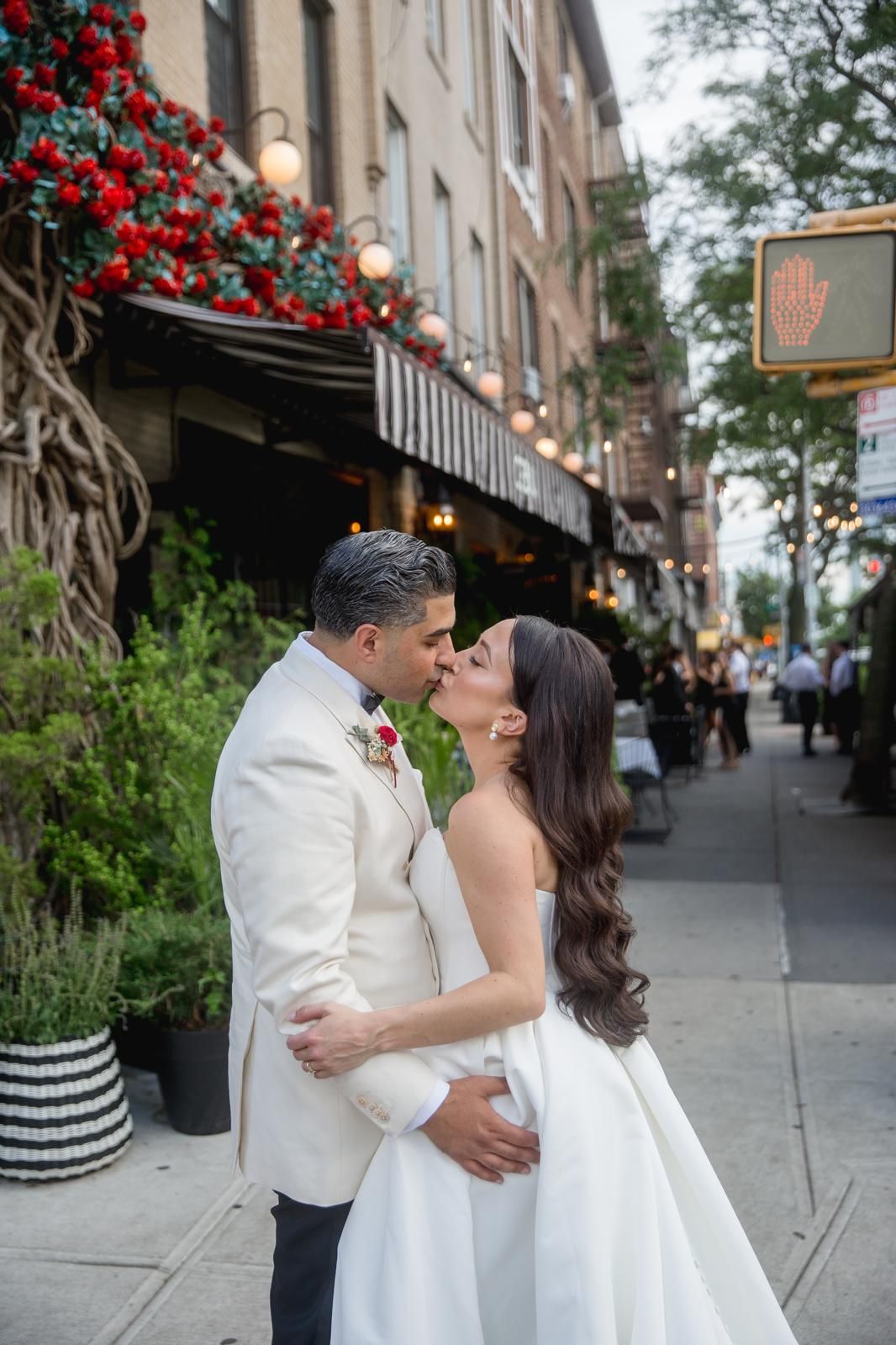 Couple kissing on a leafy New York City sidewalk