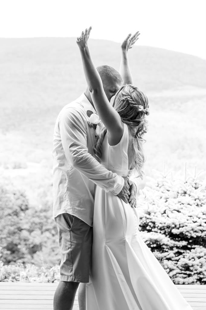 Black and white portrait of a couple celebrating with arms raised